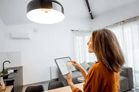 woman using tablet to control smart home lights